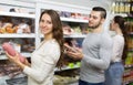 Customers near fridge with meat products Royalty Free Stock Photo