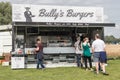 Customers queing to buy hot food at a burger vendor stall outside Royalty Free Stock Photo