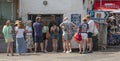 Customers queueing outside a traditional fish and chip shop, UK