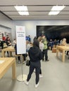 Customers standing in line waiting for online order pickup at Apple retail store in downtown Dallas, diverse group of people