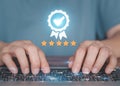 Customers using laptop to send satisfaction surveys with quality guarantee icon of 5 stars. Royalty Free Stock Photo