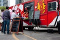 Customers Wait In Line To Order Meals From Food Truck