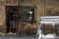 Customers wait at an old jewelry repair shop, with a tuk-tuk in front of the shop in Tabaco, the Philippines