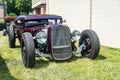 Customized classic lowrider hot rod roadster with exposed engine, big tires, and big headlights