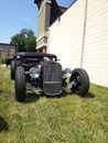 Customized classic lowrider hot rod roadster with exposed engine, big tires, and big headlights Royalty Free Stock Photo