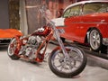 Customized motorcycle with v-twin cylinder motorcycle engine with chrome coating. Orange motorcycle frame with white flames.