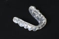 Customized transparent teeth bite guard clear aligners for lower jaw on black background