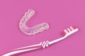 Customized transparent teeth bite guard clear aligners for lower jaw with tooth brush Royalty Free Stock Photo
