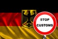 Customs sign, stop, attention against the background of the silk national flag of Germany, the concept of border and customs Royalty Free Stock Photo