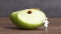 A cut apple and miniature people.