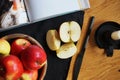 A cut apple next to other apples, a book, a candlestick and a knife on a black background Royalty Free Stock Photo