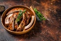 Cut BBQ grilled lamb rack spareribs in a wooden plate. Dark background. Top view. Copy space Royalty Free Stock Photo