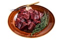 Cut Beef or veal raw heart in a rustic plate with herbs. Isolated on white background. Top view. Royalty Free Stock Photo