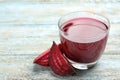 Cut beet and glass of juice on blue wooden table. Royalty Free Stock Photo