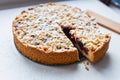 cut berry pie. slice of homemade sour cherry pie on plate and whole tart cut in slices in baking dish on napkin on wooden table, Royalty Free Stock Photo