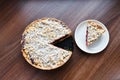 Cut berry pie. slice of homemade sour cherry pie on plate and whole tart cut in slices in baking dish on napkin on wooden table, Royalty Free Stock Photo