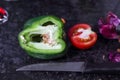 Cut capsicum and tomato and knife on granite background Royalty Free Stock Photo