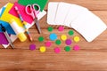 Cut cards and circle, scissors, pencil, glue stick, colored cardboard sheets on a wooden table. How to make educational flashcards