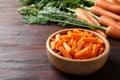 Cut carrot in bowl on brown wooden table, closeup Royalty Free Stock Photo