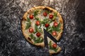 Cut cheese pizza with flour on dark concrete background top view