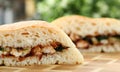 Cut chiken sandwich with ketchup against kitchen background Royalty Free Stock Photo