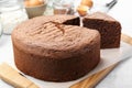 Cut chocolate sponge cake on light table, closeup Royalty Free Stock Photo