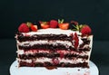 Cut creamy cake on black background, with strawberry raspberries. Dietary white from cream, with chocolate layers of Royalty Free Stock Photo