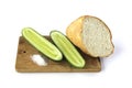 Cut cucumber and bread on a cutting board isolated on white