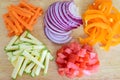 Cut and diced vegetables on a wooden cutting board. Royalty Free Stock Photo