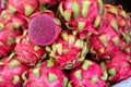 A cut dragonfruit on a pile of whole dragon fruits for sale at a market in India Royalty Free Stock Photo
