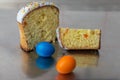 Cut Easter cake with multi-colored topping and dried fruits filling among colored Easter eggs Royalty Free Stock Photo