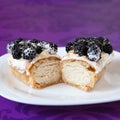 Cut eclair with cream and blackberies Royalty Free Stock Photo