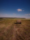 A cut field with bales, hills, wood and sky Royalty Free Stock Photo