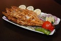 Cut fish with salad, lime slices, fresh onion rings on the white plate Royalty Free Stock Photo