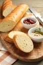 Cut fresh baguette served on wooden table, closeup Royalty Free Stock Photo