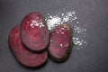 Cut fresh beetroots and salt on the black surface