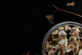 Cut fresh forest champignon mushrooms in a metallic bowl standing on black wooden table with some dry autumn leaves around Royalty Free Stock Photo