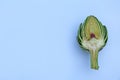 Cut fresh raw artichoke on light blue background, top view. Space for text Royalty Free Stock Photo