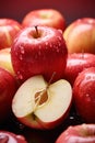 A cut fresh red apple is placed in a pile of apples