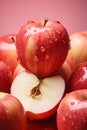 A cut fresh red apple is placed in a pile of apples