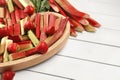 Cut fresh rhubarb stalks and strawberries on white wooden table, space for text Royalty Free Stock Photo