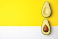 Cut fresh ripe avocado on color background, space for text Royalty Free Stock Photo