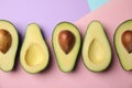 Cut fresh ripe avocados on color background