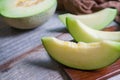 Cut of fresh sweet green melon on the wooden background. Fruits or healthcare concept. Selective focus, close up