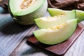 Cut of fresh sweet green melon on the wooden table. Fruits or healthcare concept. Selective focus, close up