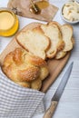Cut freshly baked braided bread, honey and butter on white wooden table, flat lay. Traditional Shabbat challah Royalty Free Stock Photo