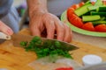 Cut green onion with a kitchen knife on a wooden cutting board. Fresh green onions on a cutting board. Royalty Free Stock Photo