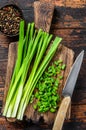 Cut Green onions chives on a cutting board. Dark wooden background. Top view Royalty Free Stock Photo