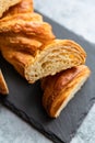 Cut in half croissant with inside texture and thin crisp layers on black board, grey background. Delicious french pastry