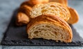 Cut in half croissant with inside texture and thin crisp layers on black board, grey background. Delicious french pastry